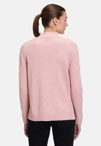 Helles rosa Sweatshirt mit geripptem Saum und weicher Textur, mit hohem Kragen und langen Ärmeln, von hinten gezeigt.