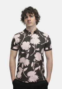 Polo shirt marrone con motivo floreale rosa, maniche corte e colletto. Texture liscia con un design aderente.