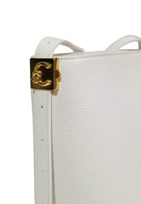 Hvid læderhåndtaske med glat tekstur, udstyret med en guldfarvet hardware-lås og et fremtrædende logo-detalje. Sidevisning fremhæver det strukturerede design.