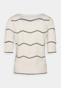 Pull en tricot crème à manches courtes, présentant un motif noir ondulé et des détails texturés le long du corps et de l'ourlet.