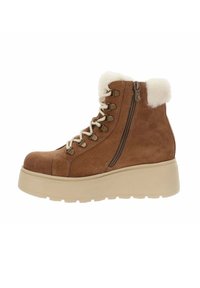 Stivaletti ankle in suede marrone con collo in pelliccia sintetica bianca, zip laterale e suola piatta di colore crema in contrasto. Lacci frontali con occhielli in metallo.