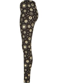 Leggings neri con un motivo di stelle e sole in tonalità crema e oro, realizzati in materiale elasticizzato, design aderente, texture liscia.