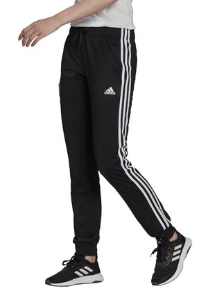 Černé sportovní kalhoty z polyesteru s bílými pruhy po stranách. Mají elastický pas se šňůrkou na stažení. Logo umístěné na stehně.