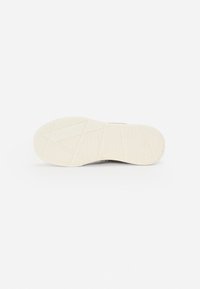 Schoenzool van wit rubber met een gestructureerd grippatroon, met diagonale lijnen en een afgeronde vorm. Schoon, minimalistisch ontwerp.
