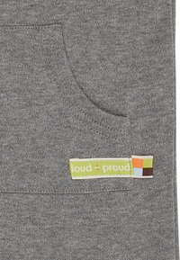 Tessuto grigio di felpa con tasca, dotato di un'etichetta colorata con la scritta "loud + proud" in accenti verdi, arancioni, blu e marroni.
