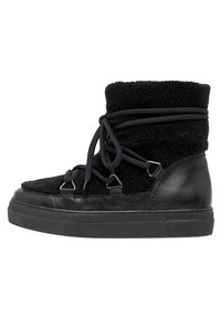 Sneakers alte nere con tomaia in pile testurizzato, dettagli in pelle e un sistema di allacciatura alla moda. Suola in gomma spessa per un supporto aggiuntivo.