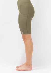 Olijfgroene geribbelde fietshorts met een hoge tailleband en zijzakdetails. Gladde textuur en ontwerp tot halverwege de dij.