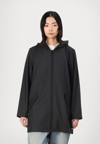 Manteau noir à capuche avec une fermeture éclair sur toute la longueur, doté de deux poches latérales et d'une silhouette décontractée. Tissu lisse et imperméable ; manches longues.