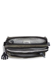 Olive green zippered wallet with multiple compartments and a black monkey charm. Sturdy fabric with a smooth texture and patterned interior lining.