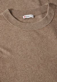 Brauner gerippter Pullover mit Rundhalsausschnitt. Weicher Stoff und lässiges Design, mit einem Etikett, das "Street One" liest.