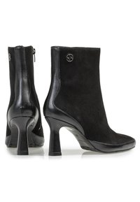 Botines negros con una combinación de ante y piel lisa, que cuentan con un diseño elegante, puntera afilada y un tacón de aguja de altura media.