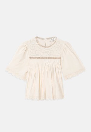 Blusa crema con mangas anchas, intrincados bordados en el pecho, borde de encaje con puntilla en las mangas y el dobladillo, y tela plisada debajo del pecho.