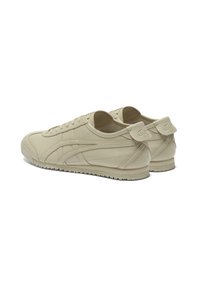 Beige Sneaker aus glattem Leder mit runder Zehenpartie, schnürbarem Vorderteil, strukturiertem Profil und dezentem Logo an der Ferse.