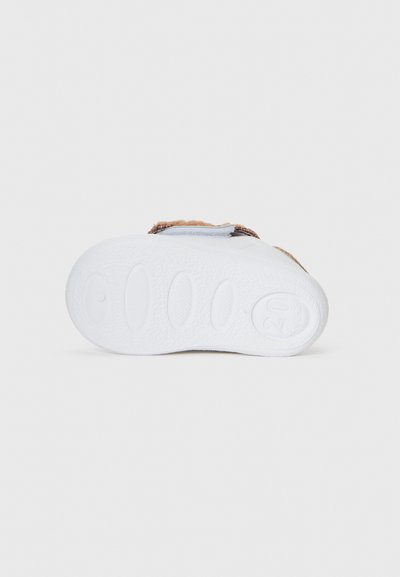 Sandale pour enfant marron et blanche avec une semelle en caoutchouc blanc texturé, une sangle Velcro et un matériau supérieur doux. Design à bout rond.