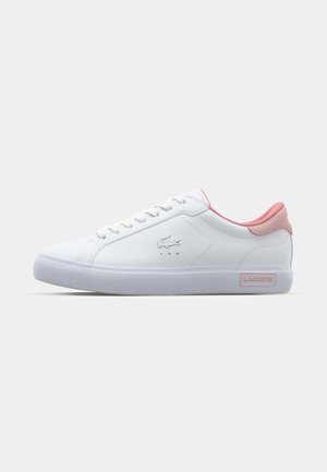 Zapatilla blanca con parte superior de cuero suave, detalles en rosa en el talón y la lengüeta, diseño de cordones y una suela de goma texturizada.