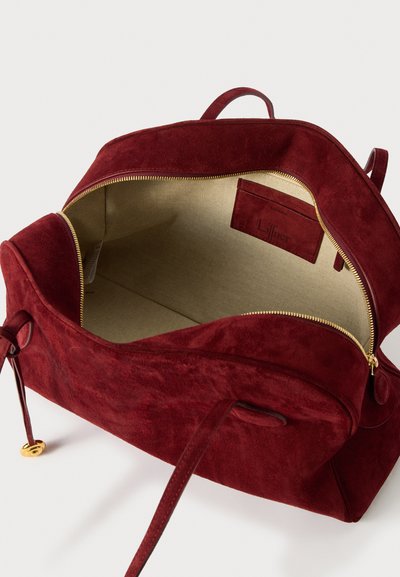 Borsa in suede borgogna con una cerniera dorata, foderata internamente di chiaro e di forma rettangolare. Presenta una tasca interna e due manici.