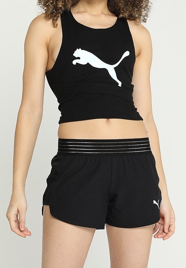 Débardeur noir côtelé avec un logo Puma blanc, associé à un short noir doté d'une ceinture élastique rayée et de poches latérales.