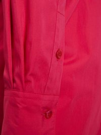 Czerwona koszula z guzikami, o gładkiej fakturze, z zapięciem na guziki i złożonymi mankietami. Tkanina wydaje się lekka i odporna na zagniecenia.