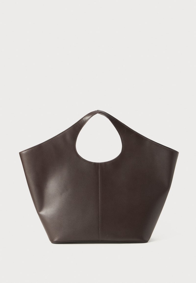 Brun läder tote-väska med ett unikt ovalt utskuret handtag, har en slät yta och en minimalistisk design; stor och öppen form.