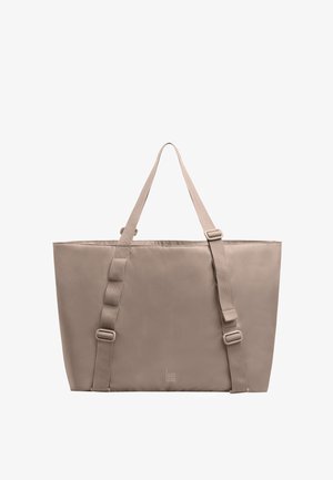 Sac fourre-tout rectangulaire beige avec deux bretelles réglables et un logo vertical minimaliste près du centre inférieur.