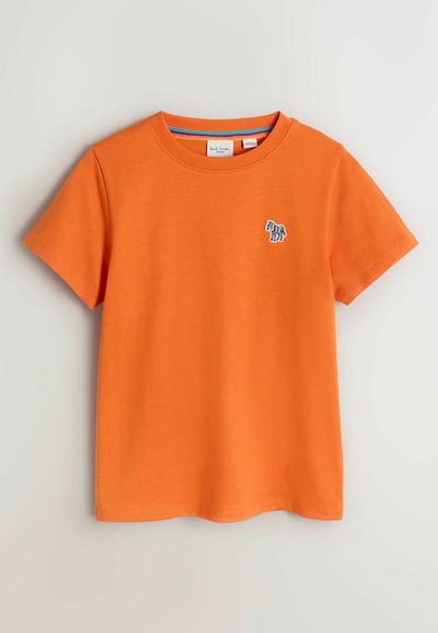 Camiseta de algodón naranja de manga corta con un diseño de cebra bordado en azul y blanco en el lado izquierdo del pecho. Cuello redondo con ribete de contraste.