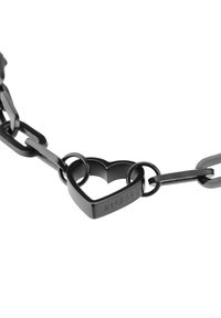 Collana nera a catena con anelli intrecciati e un elemento centrale a forma di cuore. Il cuore è inciso con "IN LIEBE." Rifinitura liscia e opaca.
