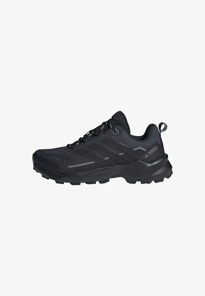 Scarpa da trail running nera a taglio basso con suola testurizzata, chiusura frontale con lacci e linguetta sul tallone, con marchi del brand Terrex.