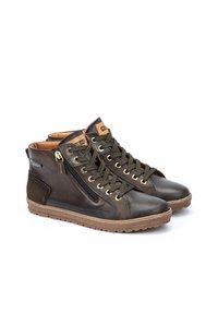 Zapatillas altas de cuero marrón con un acabado texturizado, que presentan un zipper en tono dorado, cordones redondos y una suela de goma.