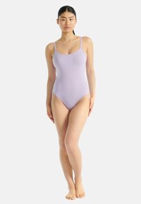 Fialový jednodílný plavky s tenkými ramínky, výstřihem ve tvaru lodi a vysoce vykrojenými nohavičkami, vyrobené z hladké, elastické tkaniny.