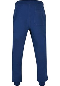 Pantaloni sport din bumbac de culoare bleumarin, cu talie elastică și manșete, având un singur buzunar la spate. Textură netedă, design cu picior îngust.