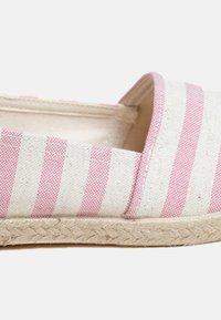 Striped espadrille with a natural canvas upper in white and pink, featuring a jute rope sole and a slip-on design.
