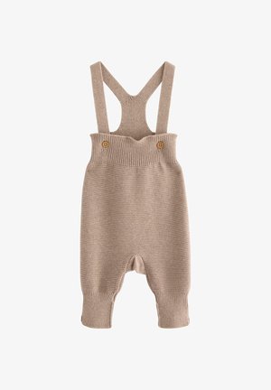 Salopette beige en tricot avec de larges bretelles, texture côtelée et deux boutons en bois à la taille. Les poignets de cheville sont également côtelés.