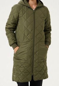 Quilted olive green coat with hood, front zipper, and two large side pockets. Features a long length and ribbed cuffs.