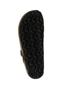 Zwarte rubberen zool met een golfpatroon, afgeronde randen en een textuur in het oppervlak. Zijaccent heeft een bruine bovenlaag.