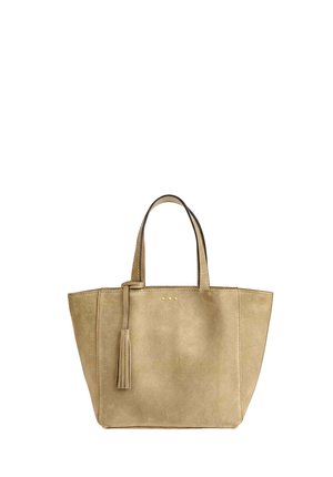 Sac cabas en daim beige avec deux poignées, un pompon suspendu à une poignée, et trois petits points dorés centrés près du haut.