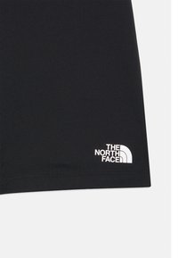 Μαύρο ύφασμα με λευκό λογότυπο The North Face τυπωμένο κοντά στο κάτω τελείωμα σε μονόχρωμο φόντο.