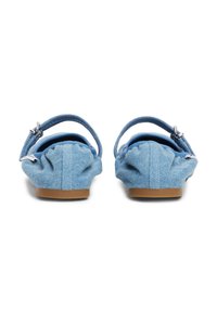 Modré džínsy slingback ploché topánky s textúrovaným povrchom, sľúbený detail na päte a hnedou gumovou podrážkou. Obsahujú tenký nastaviteľný remienok.