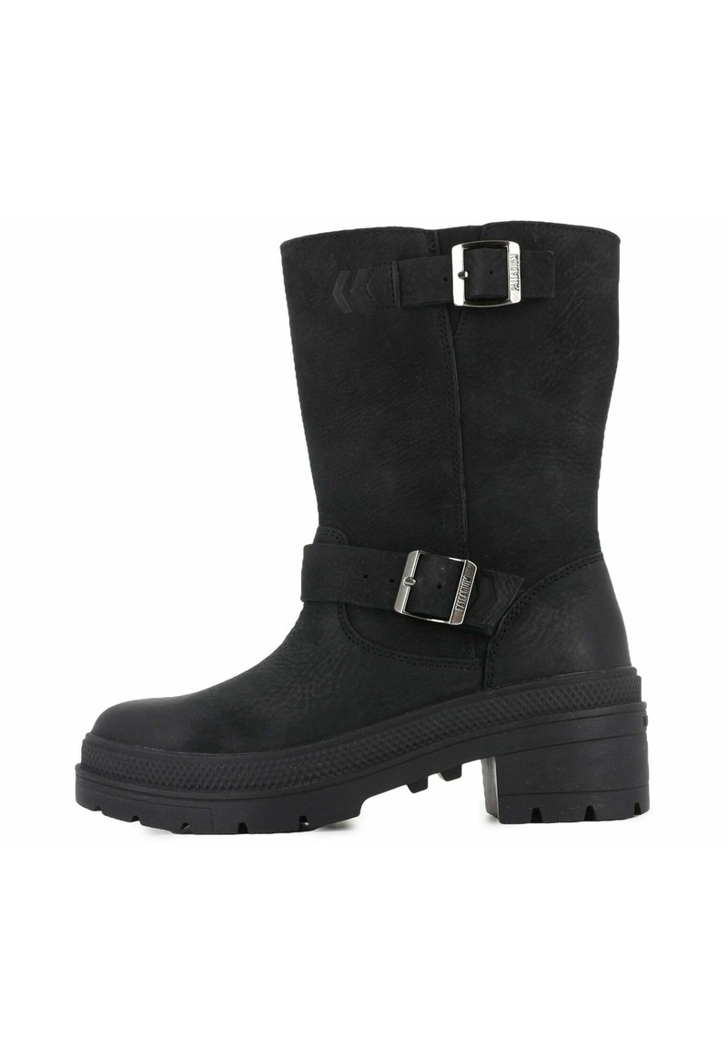 Bota negra hasta la rodilla hecha de cuero texturizado. Presenta una amplia correa y detalle de hebilla, con una suela gruesa y estriada y un tacón cuadrado.