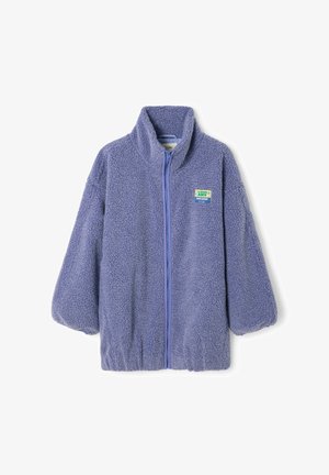 Veste en polaire lavande à fermeture éclair intégrale, avec col montant, poignets et ourlet élastiques, et une petite plaque rectangulaire sur le côté gauche de la poitrine.