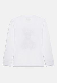 Άσπρο βαμβακερό T-shirt με μακριά μανίκια που διαθέτει διακριτικό σχέδιο αρκούδας με κέρατα στο πίσω μέρος. Λαιμόκοψη crew, μαλακή υφή, άνετη εφαρμογή.