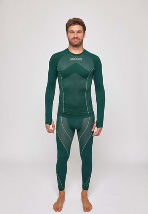 Green long-sleeve athletic shirt and leggings by Snocks with textured fabric, contrasting white seams, and a fitted design for comfort.