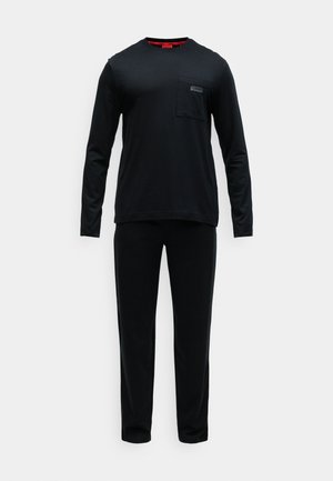 Juodas ilgos rankovės marškinėlis su apvalia iškirpte ir krūtine kišene, derinamas su atitinkamomis juodomis kelnėmis. Abu pagaminti iš minkštos medžiagos su lygiu paviršiumi.