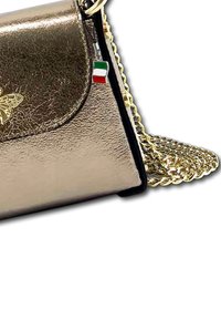 Kleine metallic handtas met gouden vlinderdetail, gouden kettingriem en een Italiaanse vlag charm die aan de rits hangt.