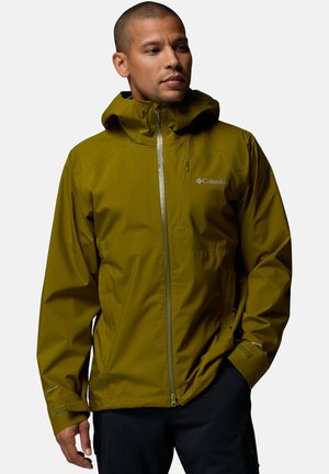 Man wearing olive green Columbia waterproof jacket with hood, zipped front, and zippered chest pocket, looking slightly to the side.