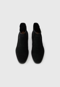 Czarne zamszowe botki za kostkę o gładkiej powierzchni, zaokrąglonej nosie, elastycznych panelach po bokach i tonowej nici. Prosty, minimalistyczny design.