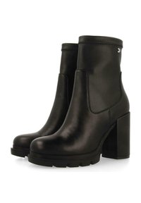 Botas de piel negra hasta el tobillo con un tacón robusto, diseño elegante, paneles laterales elásticos y una suela texturizada para un mejor agarre.