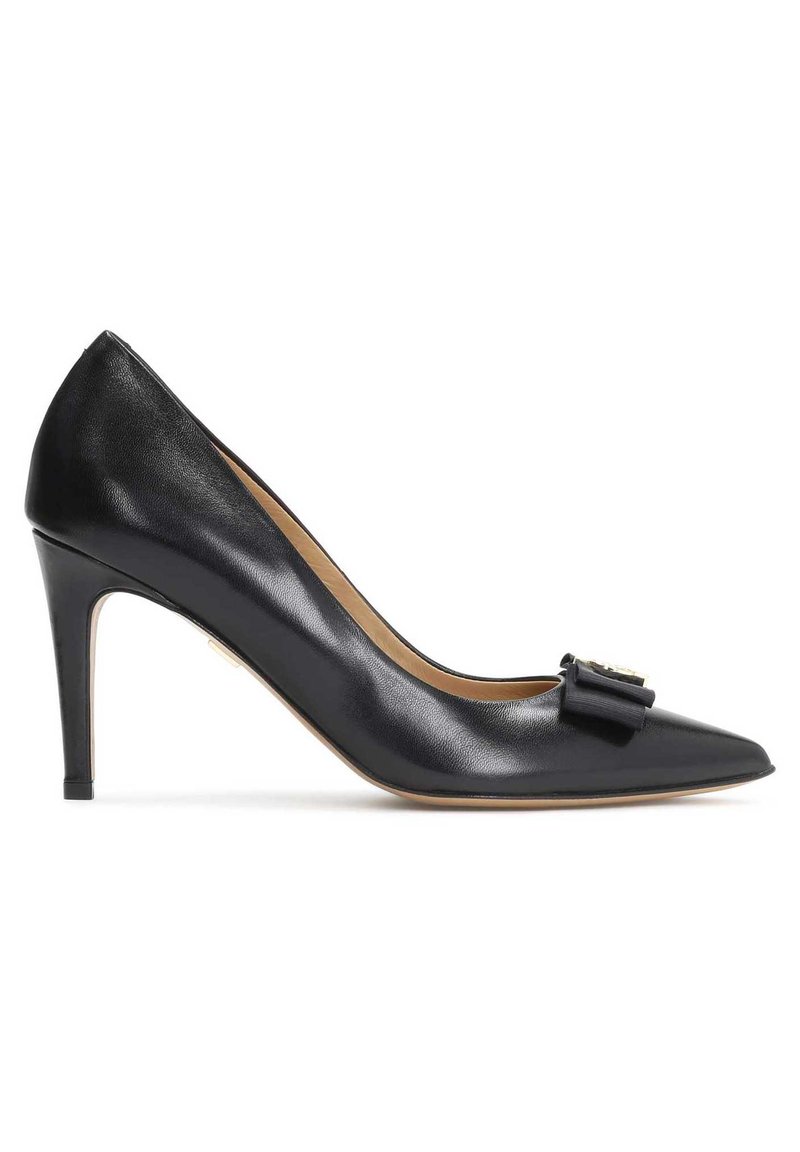 Pompa nera in pelle con tacco alto e punta affilata, caratterizzata da un dettaglio a fiocco decorativo e un tacco stiletto sottile. Texture liscia.
