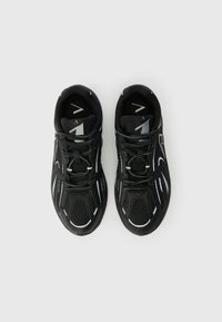 Adidași negri cu panouri din plasă, accente reflectorizante și o talpă texturată. Prezintă șireturi negre și un model geometric pe partea superioară.