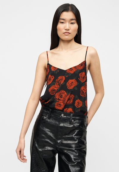 Μαύρο καμιζολάκι με μοτίβο κόκκινης τριανταφυλλιάς, λεπτές ρυθμιζόμενες τιράντες και ντεκολτέ σε σχήμα V, σε συνδυασμό με μαύρο παντελόνι από συνθετικό δέρμα με ψηλή μέση.