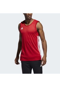 Débardeur de sport rouge avec un col rond, présentant trois bandes blanches sur les côtés et un logo Adidas sur la poitrine. Texture lisse.